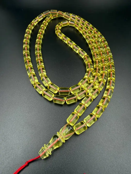 Full coil — finished transparent amber misbaha strand photographed in the VIAMBER atelier