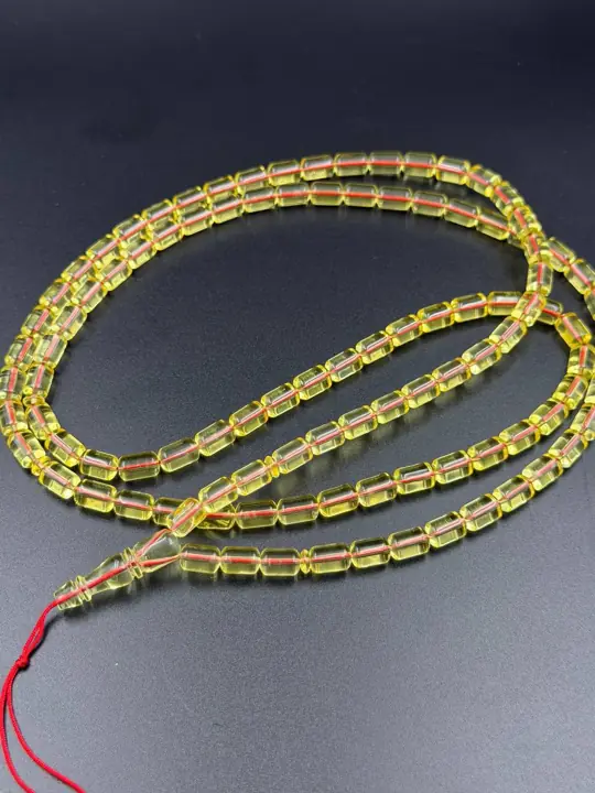 Coil, wide — finished transparent amber misbaha strand photographed in the VIAMBER atelier